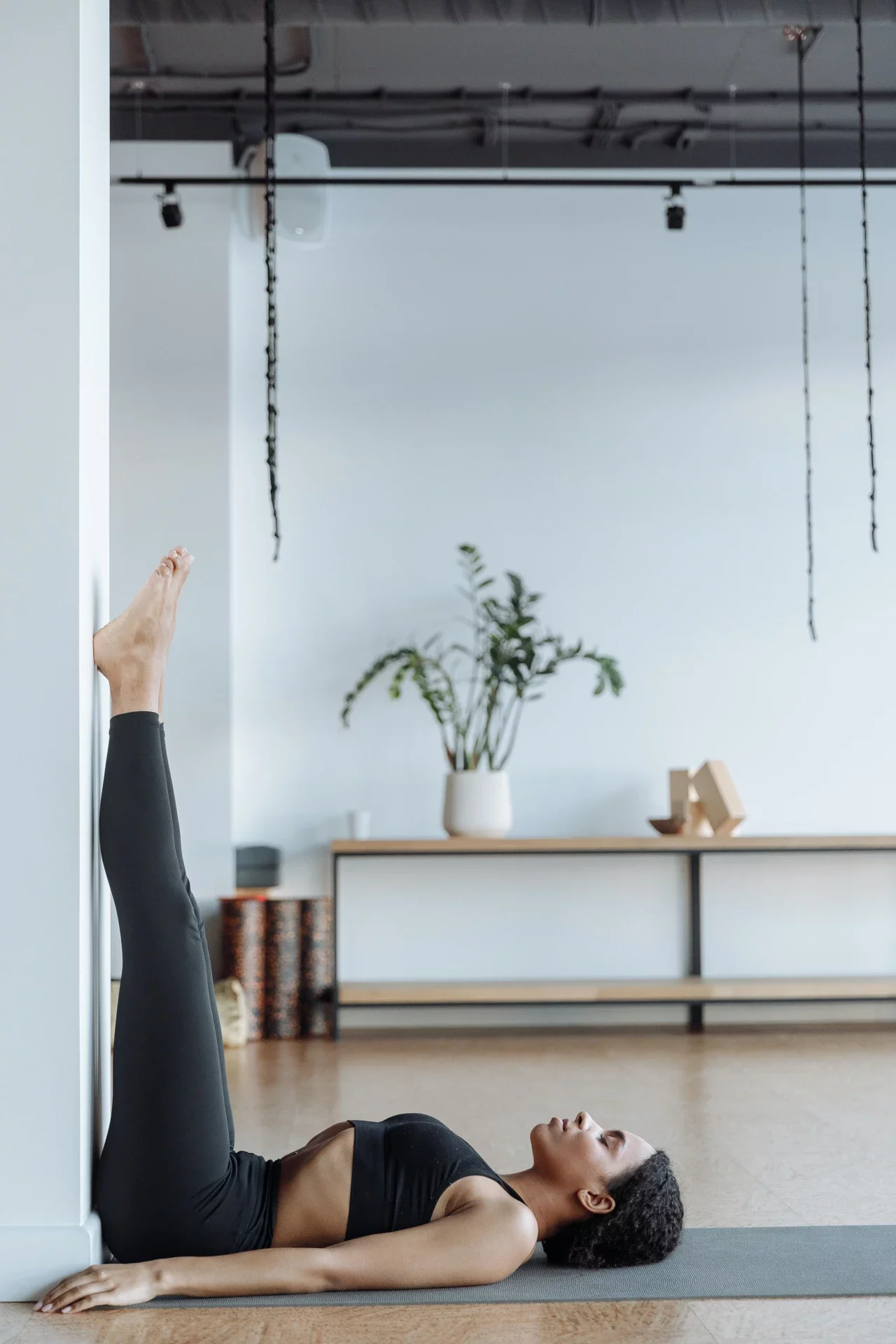 Frau macht Hatha Yoga an der Wand